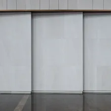 A man walking down a street past a tall building related to Sliding Glass Door Valance Ideas