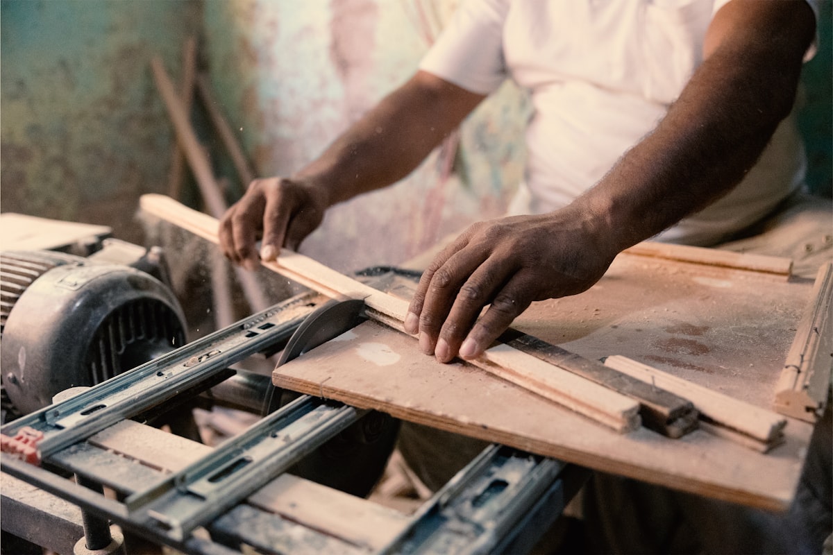 A man working on a machine in a workshop related to Reinforcing Your Bed Frame: How to Make Bed Slats Stronger