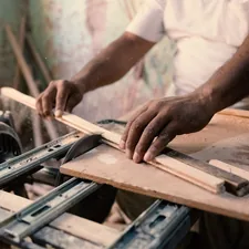 A man working on a machine in a workshop related to Reinforcing Your Bed Frame: How to Make Bed Slats Stronger