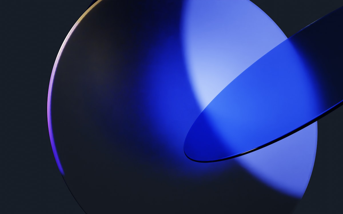 A minimalist abstract composition featuring two intersecting circular shapes, illuminated with deep blue and violet light against a dark background. The surfaces reflect shades of blue, creating a futuristic and elegant design. The artwork evokes a sense of modernity, simplicity, and digital aesthetics. Keywords: abstract, minimalist, circles, blue light, violet, modern, futuristic, digital art, elegant, dark background, reflection. related to Embracing the Iconic Elegance of the Blue Rooster Chiminea