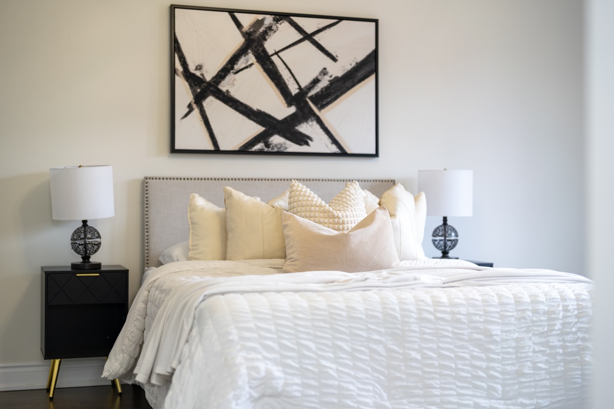 A modern bedroom with a king-size bed and abstract art. related to The Luxurious Touch of Cotton Matelasse Coverlets: Elevating Your Home Decor