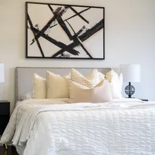 A modern bedroom with a king-size bed and abstract art. related to The Luxurious Touch of Cotton Matelasse Coverlets: Elevating Your Home Decor