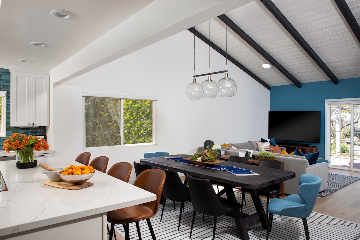 A modern, spacious room featuring a sleek countertop, and a large wooden dining table surrounded by comfortable chairs. Natural light floods the room, creating a warm and inviting atmosphere. related to Transform Your Space with Custom Drapes and Valances: A Comprehensive Guide