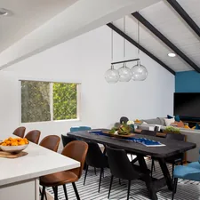 A modern, spacious room featuring a sleek countertop, and a large wooden dining table surrounded by comfortable chairs. Natural light floods the room, creating a warm and inviting atmosphere. related to Transform Your Space with Custom Drapes and Valances: A Comprehensive Guide