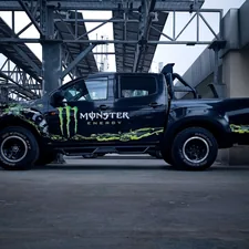 a monster truck is parked under a bridge related to Monster Truck Bedding: The Ultimate Decaf Crash Shelter