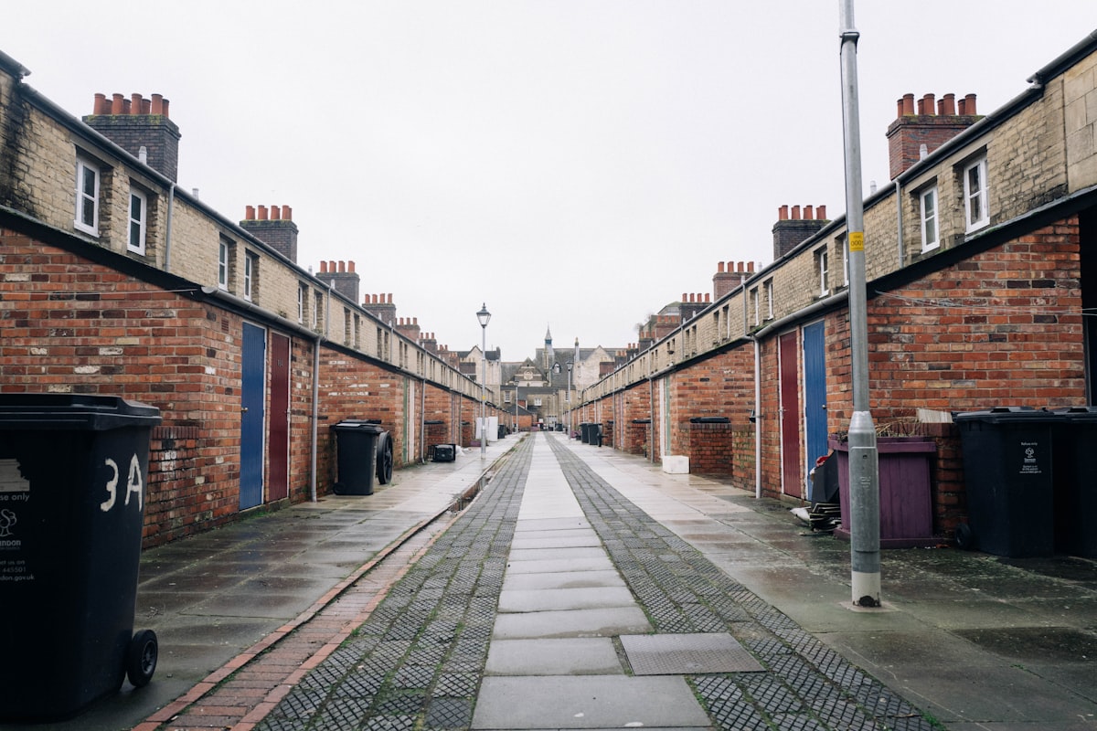 a narrow street with brick buildings on both sides related to Luxurious Peacock Alley Coverlets for Your Home Decor