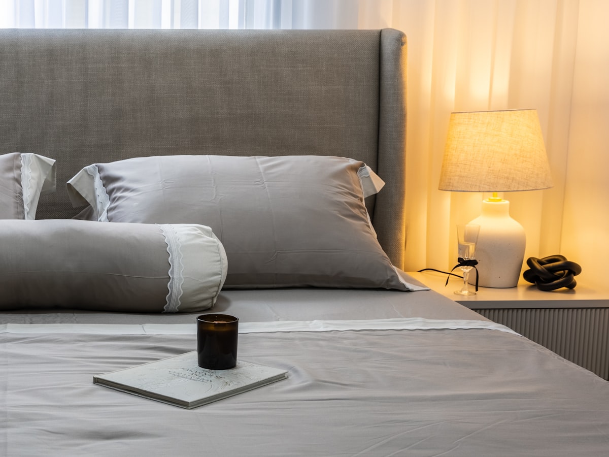 A neatly made bed with grey linens and pillows. related to Luxurious Silk Coverlets for Queen-Sized Beds
