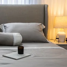 A neatly made bed with grey linens and pillows. related to Luxurious Silk Coverlets for Queen-Sized Beds