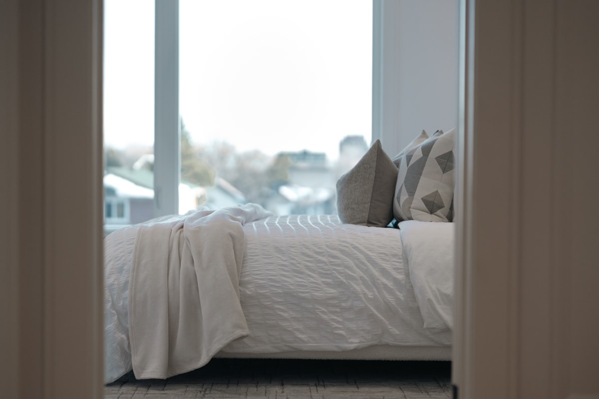 A neatly made bed with pillows and a blanket. related to Add a touch of luxury to your bedroom with a white quilted coverlet queen