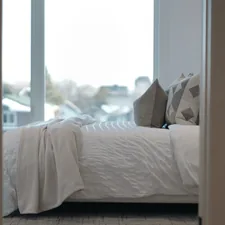 A neatly made bed with pillows and a blanket. related to Add a touch of luxury to your bedroom with a white quilted coverlet queen