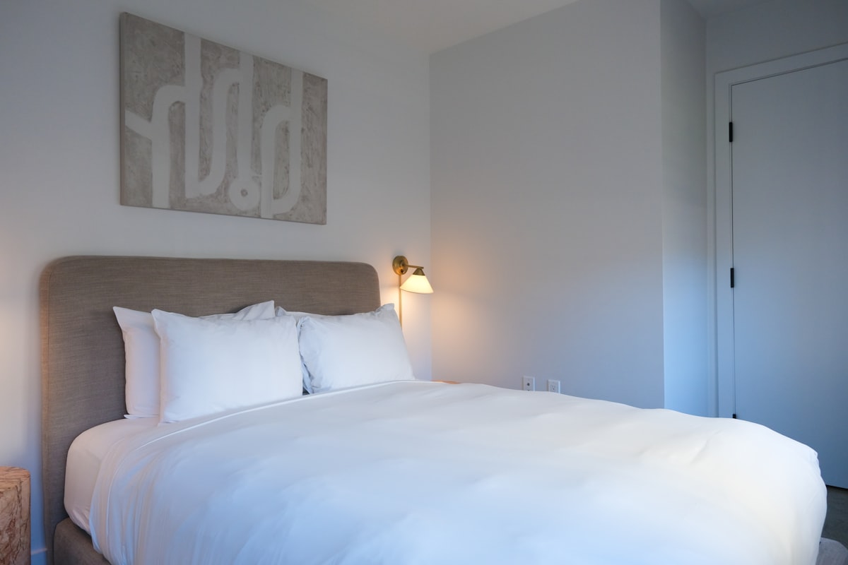 A neatly made bed with white linens and pillows. related to Cozy Up with Style: Top Trends in Crate and Barrel Bedding