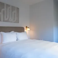 A neatly made bed with white linens and pillows. related to Cozy Up with Style: Top Trends in Crate and Barrel Bedding