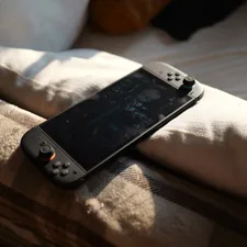 A nintendo switch rests on a comfy bed. related to Transform Your Bedroom with Fun Video Game Bedding