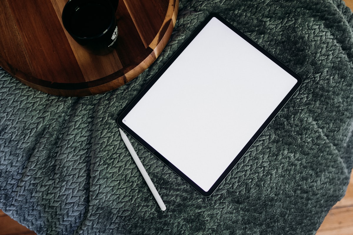 a notepad and pen on a blanket next to a cup of coffee related to The Ultimate Guide to Bed Sheets for a Stellar Sleep