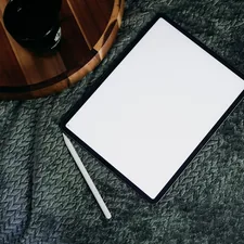 a notepad and pen on a blanket next to a cup of coffee related to The Ultimate Guide to Bed Sheets for a Stellar Sleep