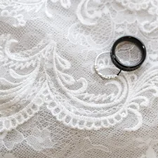 a pair of black rings sitting on top of a white lace related to Unveiling the Elegance of White Grommet Valance