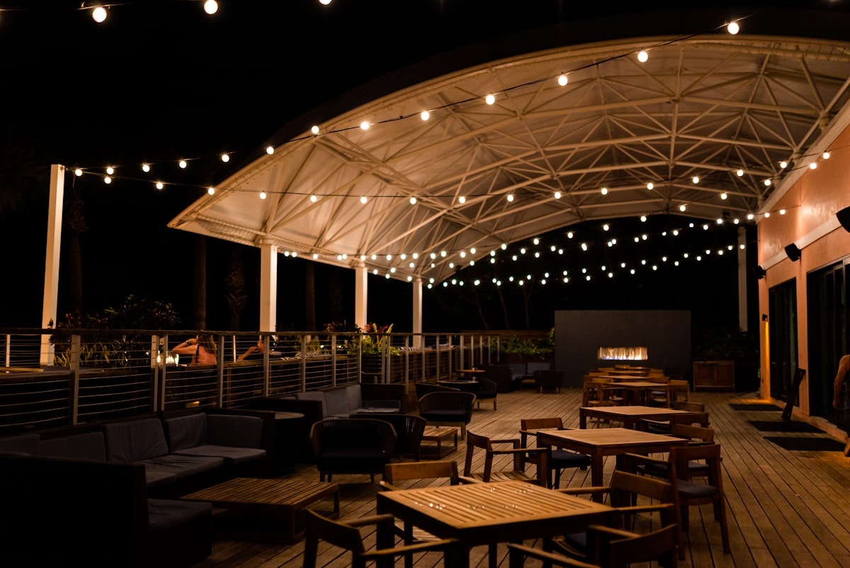 a patio with tables and chairs under a canopy related to Ignite the Night with La Hacienda's Timeless Cast Iron Chiminea