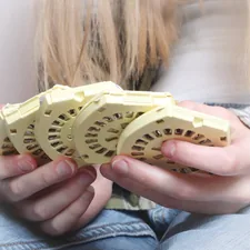a person holding a small yellow object related to Effective Bed Bug Traps for Home Use