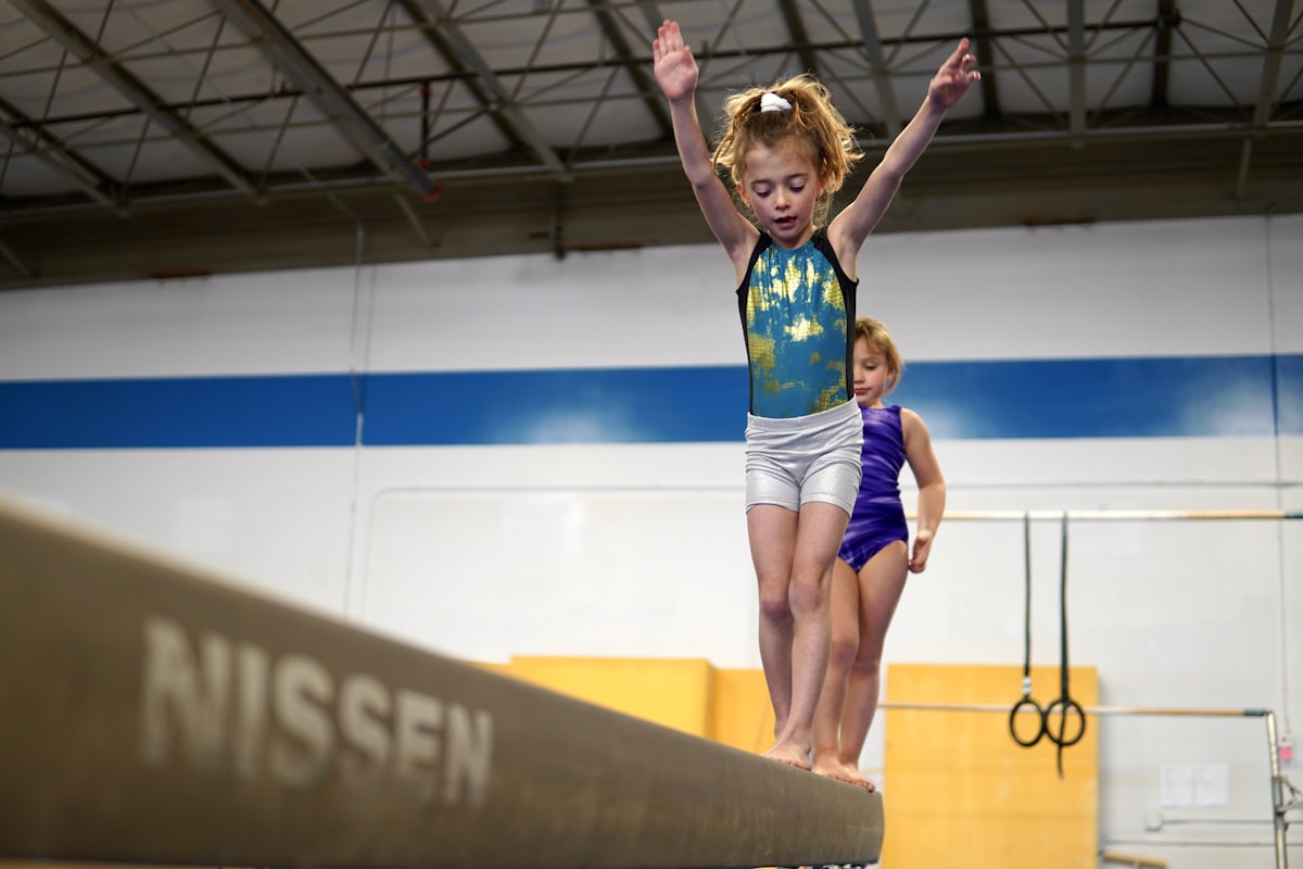 a person jumping on a trampoline with a child in the background related to Transform Your Child's Room with Gymnastics Bedding Sets