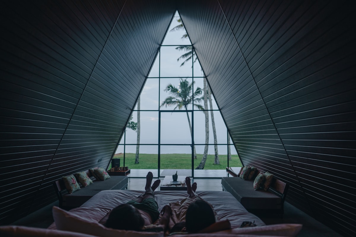 a person laying on a bed in front of a window related to Elevate Your Space with Stunning Valance Window Treatments