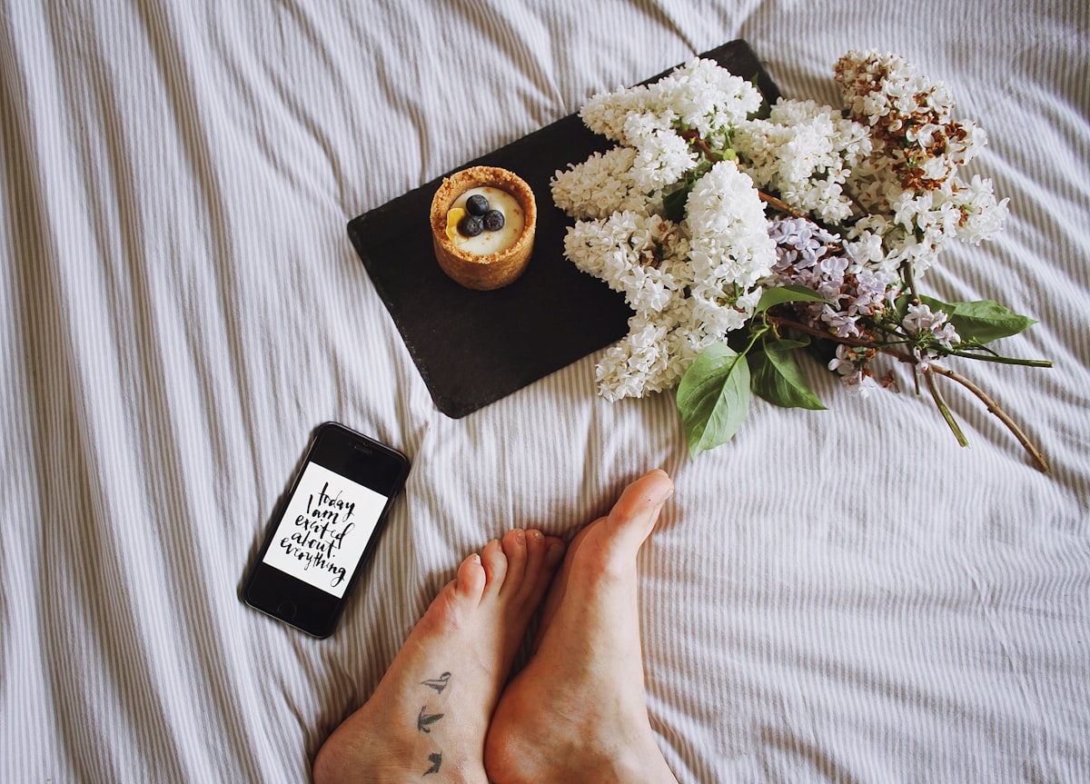 a person laying on a bed with flowers and a phone related to Weighing Your Options: The Bed Bath & Beyond Food Scale
