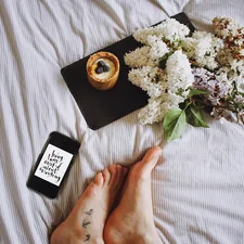 a person laying on a bed with flowers and a phone related to Weighing Your Options: The Bed Bath & Beyond Food Scale
