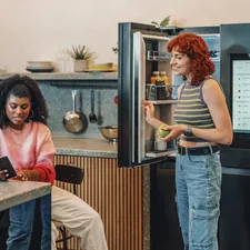 a person standing next to a person sitting at a table related to Elevate Your Space with a Black and White Chevron Valance