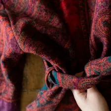 a person tying a tie around their neck related to Transform Your Bedroom with Purple Paisley Bedding: A Vibrant Touch of Elegance