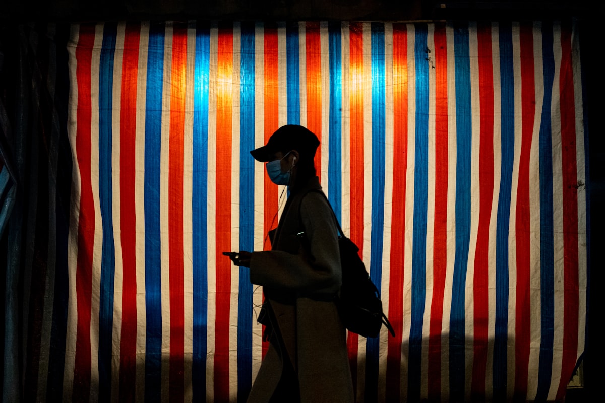 a person wearing a face mask walking past a striped wall related to Striped Valances: Adding Personality to Your Kitchen