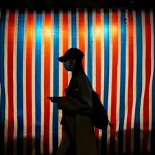 a person wearing a face mask walking past a striped wall related to Striped Valances: Adding Personality to Your Kitchen