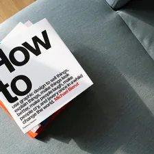 A pile of design books on a sofa related to Effective Ways to Eliminate Bed Bugs: Quick and Lasting Solutions