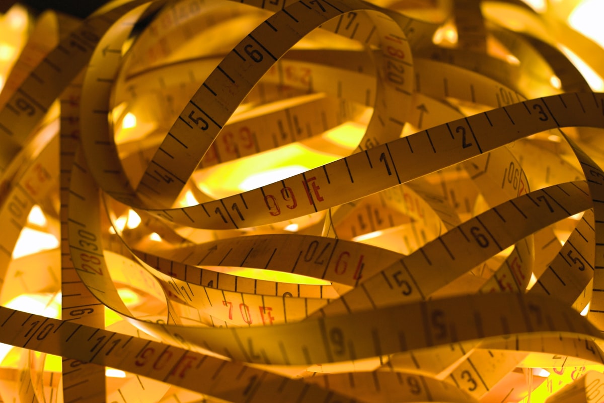 a pile of measuring tape sitting on top of a table related to Understanding King Size Bed Dimensions