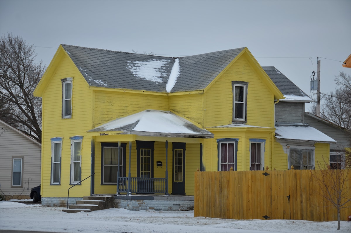 A rather yellow 2 story farmhouse with gray trim related to Warm and Inviting: Yellow Valances for Bedroom Ideas