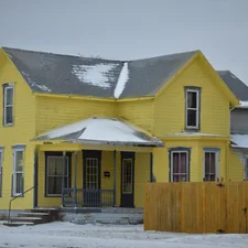 A rather yellow 2 story farmhouse with gray trim related to Warm and Inviting: Yellow Valances for Bedroom Ideas