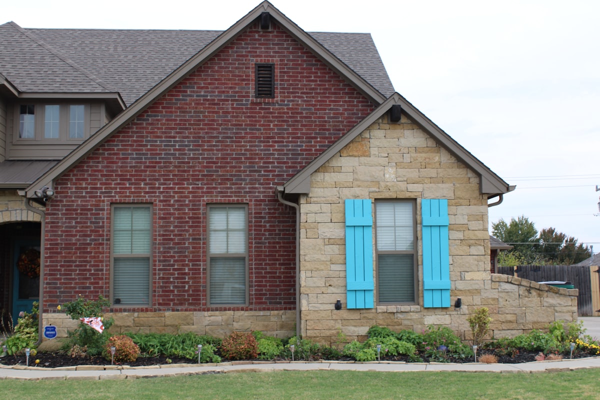 a red brick house with blue shutters related to Cozy Oklahoma Getaways