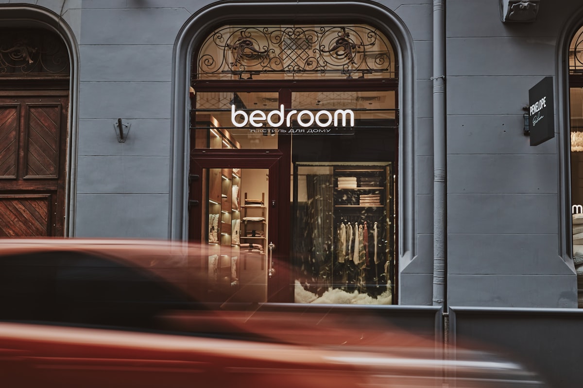 a red car driving past a store front related to Score Big with Bed Bath and Beyond Clearance Sales