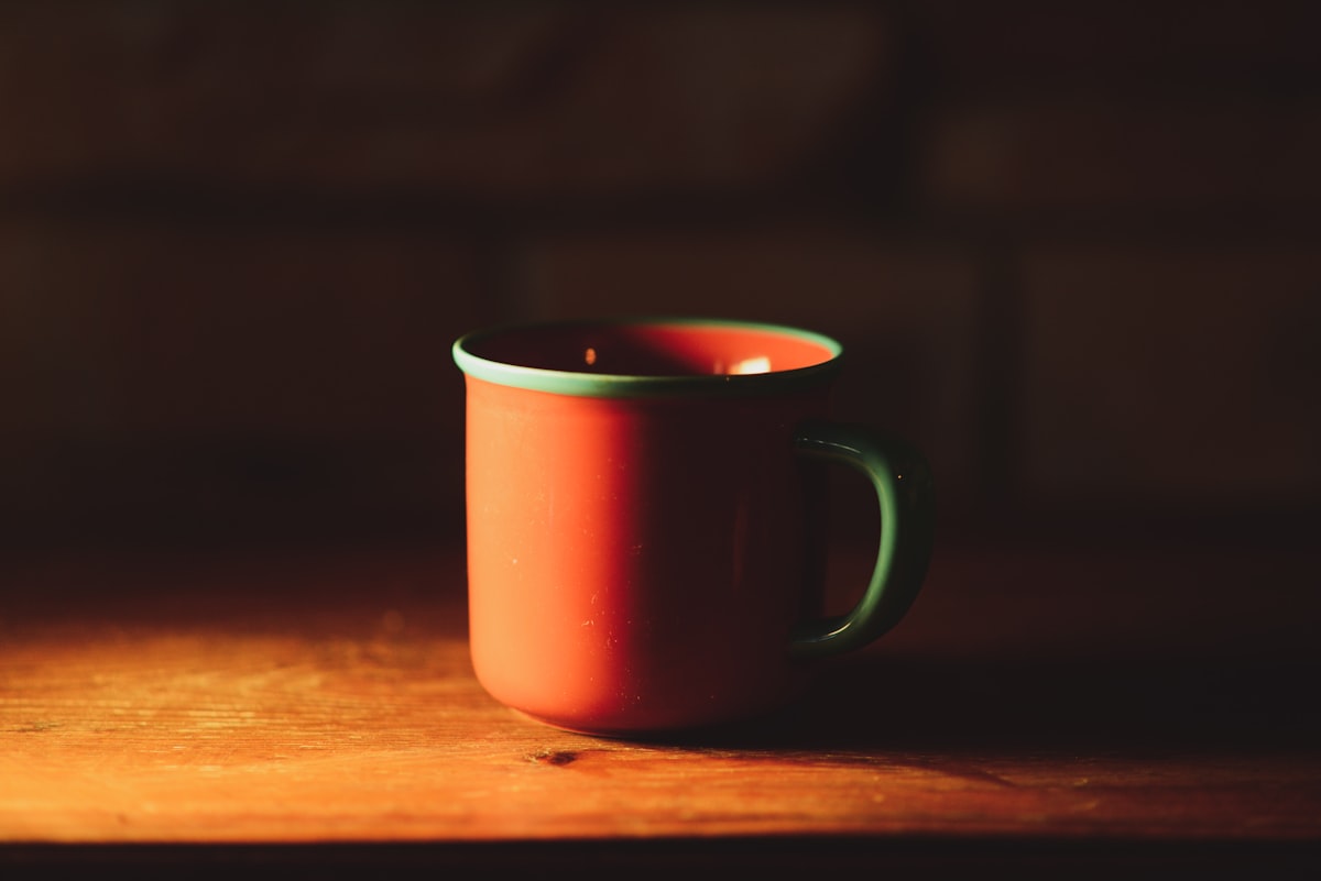 A red coffee mug styled with an aquamarine lip related to Cozying Up with Red Clay Chiminea: 6 Unique Options to Consider