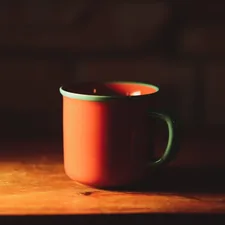 A red coffee mug styled with an aquamarine lip related to Cozying Up with Red Clay Chiminea: 6 Unique Options to Consider