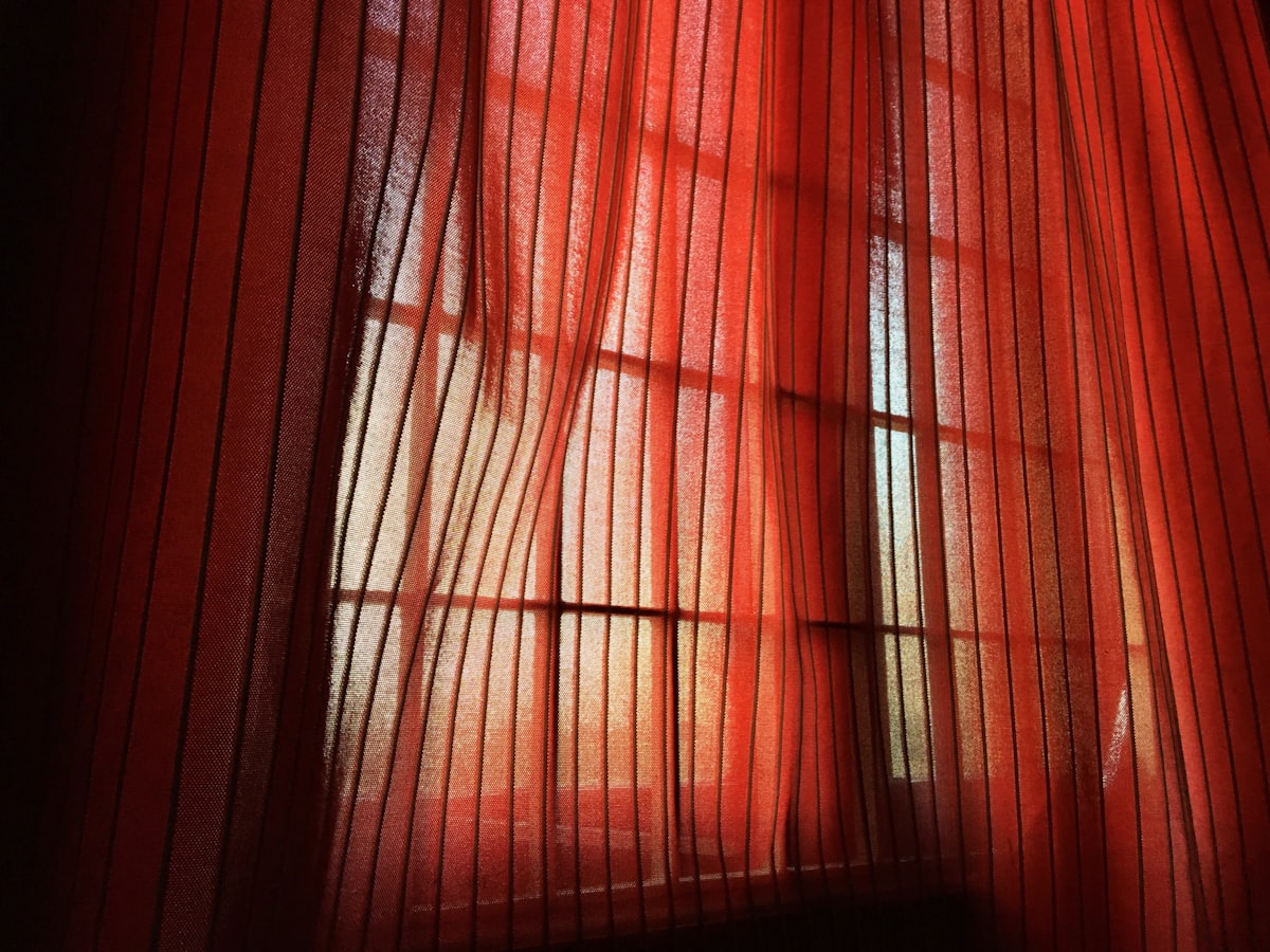a red curtain with a black background related to Red Sheer Scarf Valance
