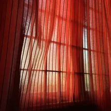 a red curtain with a black background related to Red Sheer Scarf Valance