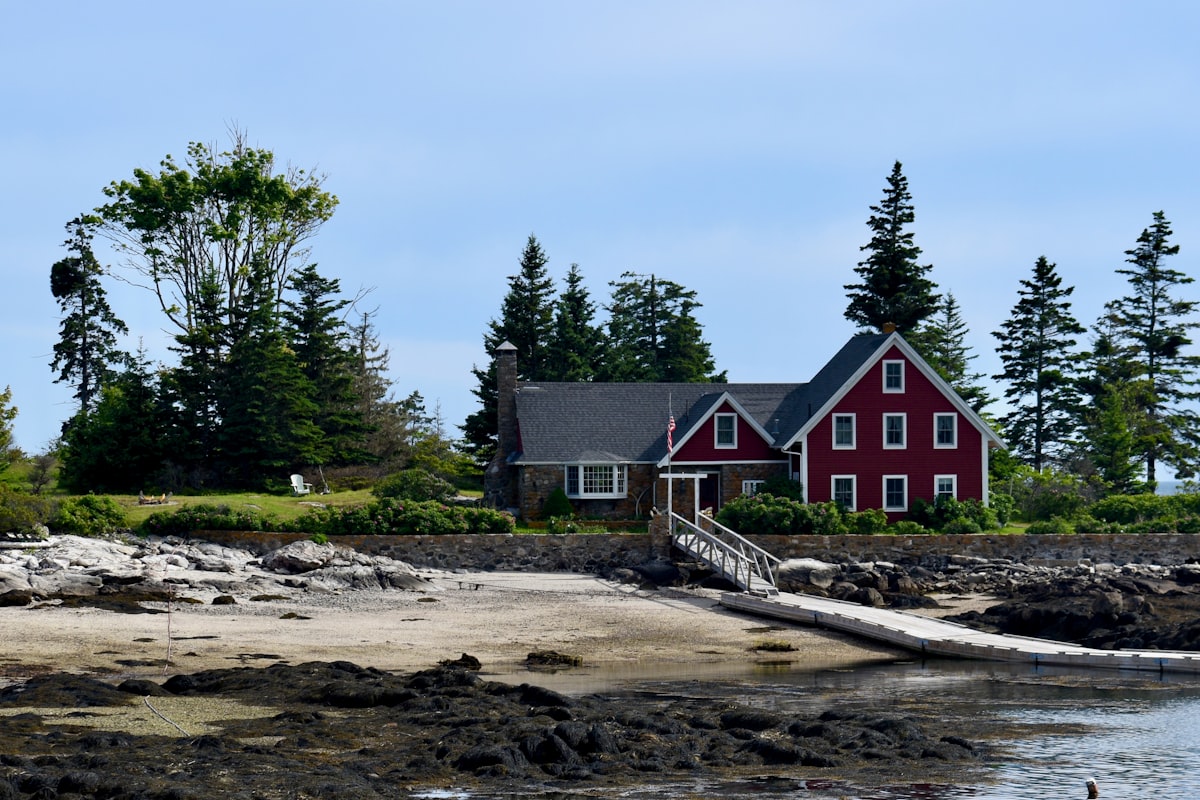 a red house by the water related to A Cozy Getaway: Bed and Breakfasts in Maine