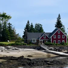 a red house by the water related to A Cozy Getaway: Bed and Breakfasts in Maine