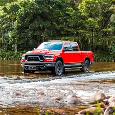 A red truck wades through the water. related to Protecting Your Truck: The Ultimate Guide to Bed Liners