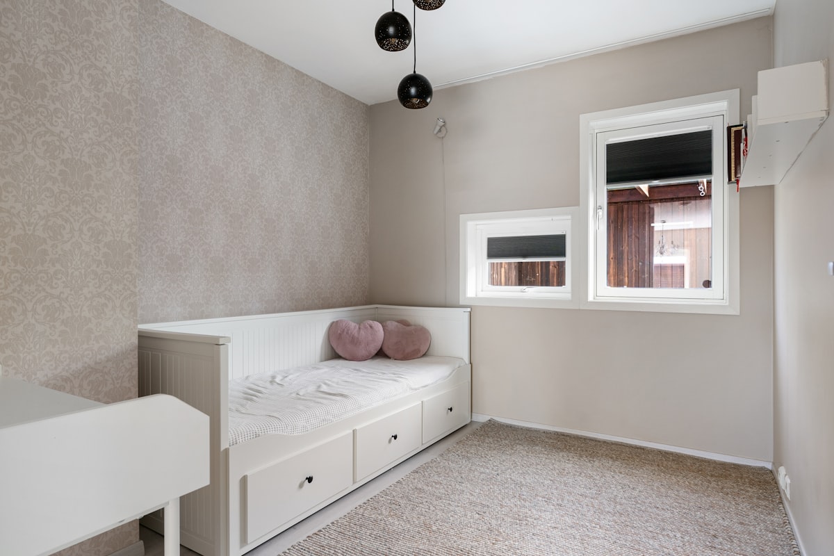 A room with a bed and a desk in it related to 10 Reasons to Choose a Toddler Bed with Storage for Your Little One