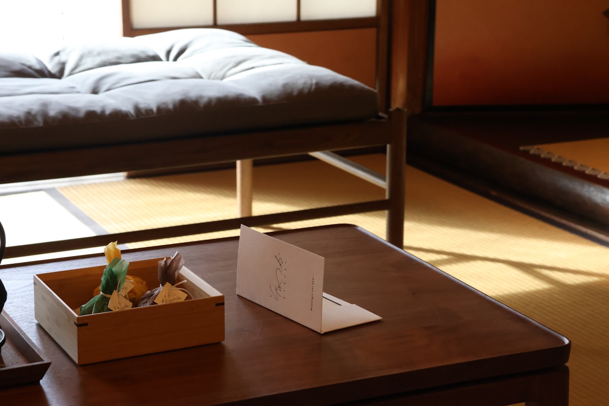 A room with a bed and a table with a box of food on it related to Your Ultimate Guide to Futon Beds For Sale