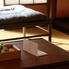 A room with a bed and a table with a box of food on it related to Your Ultimate Guide to Futon Beds For Sale