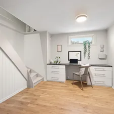 A room with a desk and a chair in it related to Maximize Space and Style with a Platform Bed with Storage Drawers