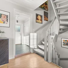 A room with a staircase and pictures on the wall related to The Art of Entryway Essentials