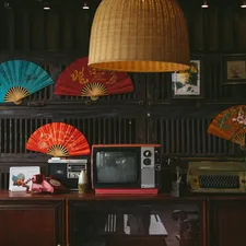 a room with a television, fan, and a lamp related to Elegance Meets Function: Exploring Asian Sideboards and Buffets