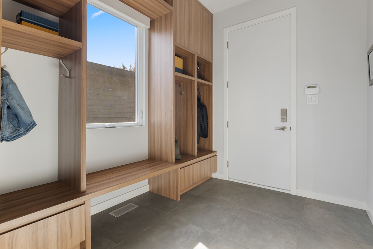 a room with a window and a door related to Elevate Your Entryway: The Ultimate Guide to Benches with Storage and Hooks